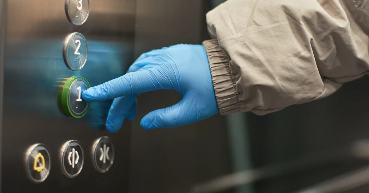 close-up-woman-protective-gloves-pushing-button-elevator